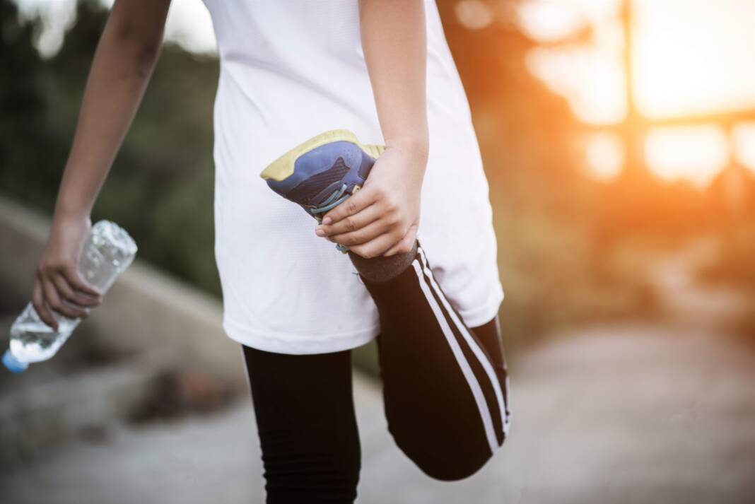 Young fitness woman hand holding water bottle after running exer